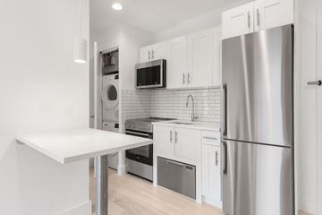 Brooklyn apartment for rent - A modern kitchen with a stainless steel refrigerator and white cabinets.