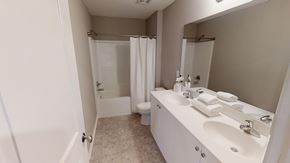 Shawnee apartment for rent - A white bathroom with a sink, mirror, toilet, and shower.