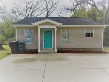 Tallahassee house for rent - a small tan house with a green door and a driveway