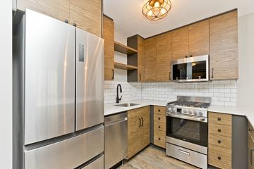 Chicago apartment for rent - a kitchen with stainless steel appliances and wooden cabinets