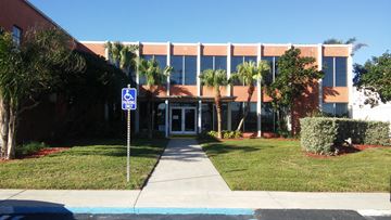 Cape Canaveral apartment for rent - A building with a blue sign in front of it.