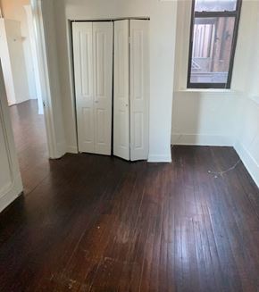 Baltimore apartment for rent - a living room with wood floors and two closet doors