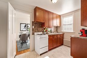 Lancaster apartment for rent - a kitchen with wooden cabinets and white appliances and a dining room table