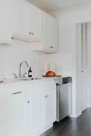Willoughby apartment for rent - a small kitchen with white cabinets and a sink and a dishwasher