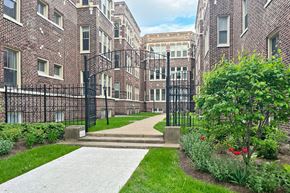 Oak Park apartment for rent - A brick building with a black fence and a walkway in front.