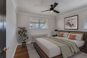 Denver apartment for rent - a bedroom with a large bed and a ceiling fan