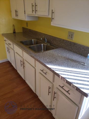 Buena Park apartment for rent - A kitchen with white cabinets and a granite countertop.