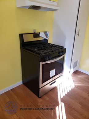 Buena Park apartment for rent - A black oven with a stainless steel handle is in a room with yellow walls.