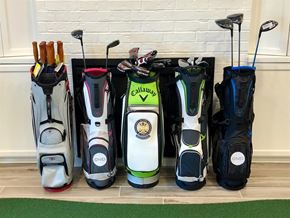 Gulf Shores apartment for rent - A collection of golf bags and clubs are displayed in front of a white brick wall.