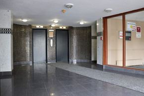 Toronto apartment for rent - the lobby of a building with four elevators and a stone bench