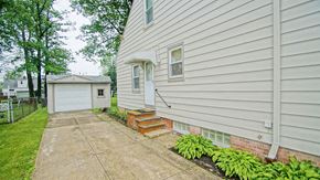 Mayfield Heights apartment for rent - A house with a white siding and a small front yard with a concrete walkway.