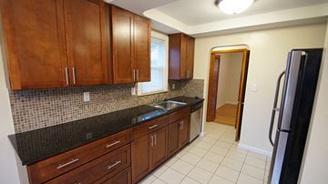 Mayfield Heights apartment for rent - A kitchen with brown cabinets and a black refrigerator.