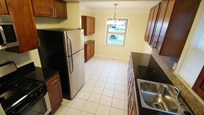 Mayfield Heights apartment for rent - A kitchen with black and white appliances and brown cabinets.