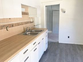 Berea triplex for rent - an empty kitchen with white cabinets and a sink