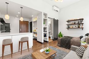 Denver apartment for rent - A modern living room with a grey sofa, wooden chairs, and a coffee table.
