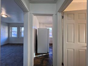 Homestead apartment for rent - A white door is open to a room with a window and a white refrigerator.