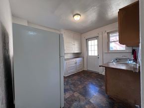 Homestead apartment for rent - A kitchen with a refrigerator, sink, and cabinets.