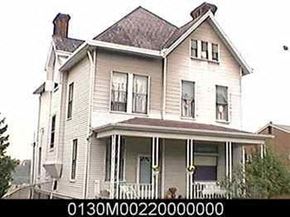 Munhall apartment for rent - A white house with a dark roof and a chimney.
