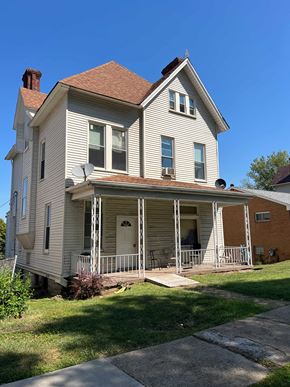 Munhall apartment for rent - A two-story house with a porch and a satellite dish on the roof.