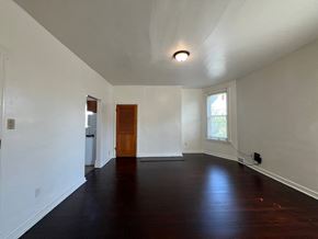 Munhall apartment for rent - A room with a wooden floor and a brown door.