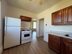Munhall apartment for rent - A kitchen with a white fridge, stove, and cabinets.