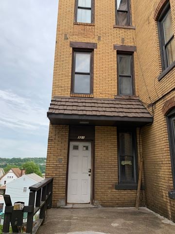 Homestead apartment for rent - A brown brick building with a white door and windows.