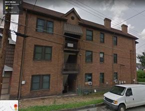 Munhall apartment for rent - a white van parked in front of a brick building