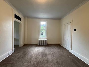 Homestead house for rent - the living room of a house with carpet and a window