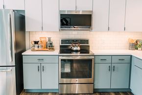 St. Louis apartment for rent - a kitchen with blue cabinets and a stove and a microwave