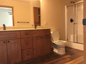 Lincoln house for rent - A white toilet sits in a bathroom with wooden cabinets.