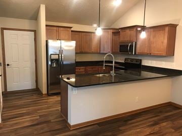 Lincoln house for rent - A kitchen with wooden cabinets and a black countertop.