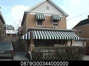 Clairton house for rent - a house with a striped awning and a car parked