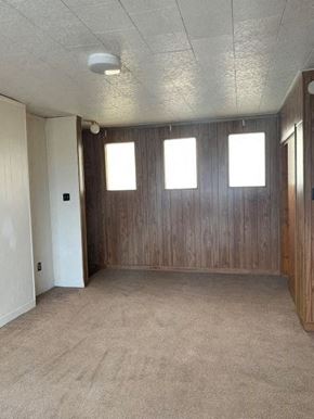 West Homestead apartment for rent - A room with wooden walls and carpeted floor.