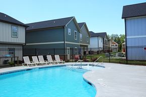 Kennesaw apartment for rent - a swimming pool with chaise lounge chairs in front of apartment buildings