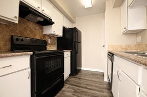 Houston apartment for rent - a kitchen with black appliances and white cabinets