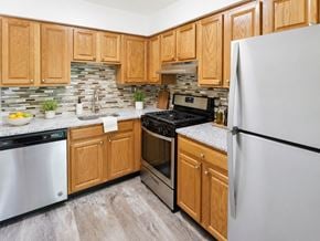 Levittown apartment for rent - A kitchen with wooden cabinets and a white refrigerator.