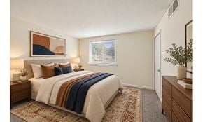 Levittown apartment for rent - A bedroom with a bed, nightstand, and a painting on the wall.
