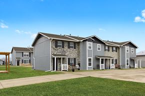 Tonganoxie apartment for rent - an apartment building with a driveway and a green lawn
