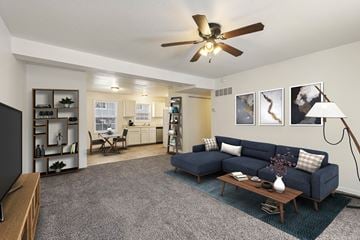 Tonganoxie apartment for rent - a living room with a blue couch and a ceiling fan