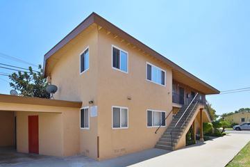 Downey apartment for rent - A two-story building with a red door and a staircase leading to the second floor.