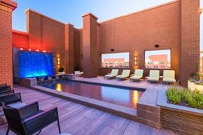 Arlington apartment for rent - a pool with a blue waterfall in the corner of a building