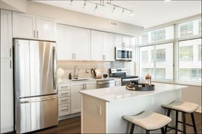 Arlington apartment for rent - a kitchen with white cabinets and a stainless steel refrigerator