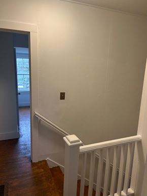 Talladega apartment for rent - A white wall with a dark brown door and a white railing.