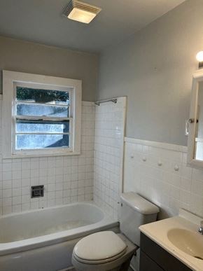 Talladega apartment for rent - A white toilet sits next to a bathtub in a bathroom.
