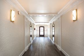San Francisco apartment for rent - A long hallway with white walls and wood floors.