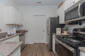 Moon apartment for rent - a kitchen with stainless steel appliances and white cabinets
