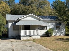 Talladega house for rent - A white house with a porch and a grey roof.