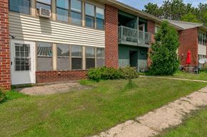 Gouverneur apartment for rent - the front yard of an apartment building with grass and a sidewalk