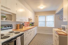 Portland apartment for rent - a kitchen with white cabinets and appliances and a window