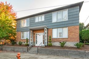 Portland apartment for rent - the front of a brick house with a white door and blue siding